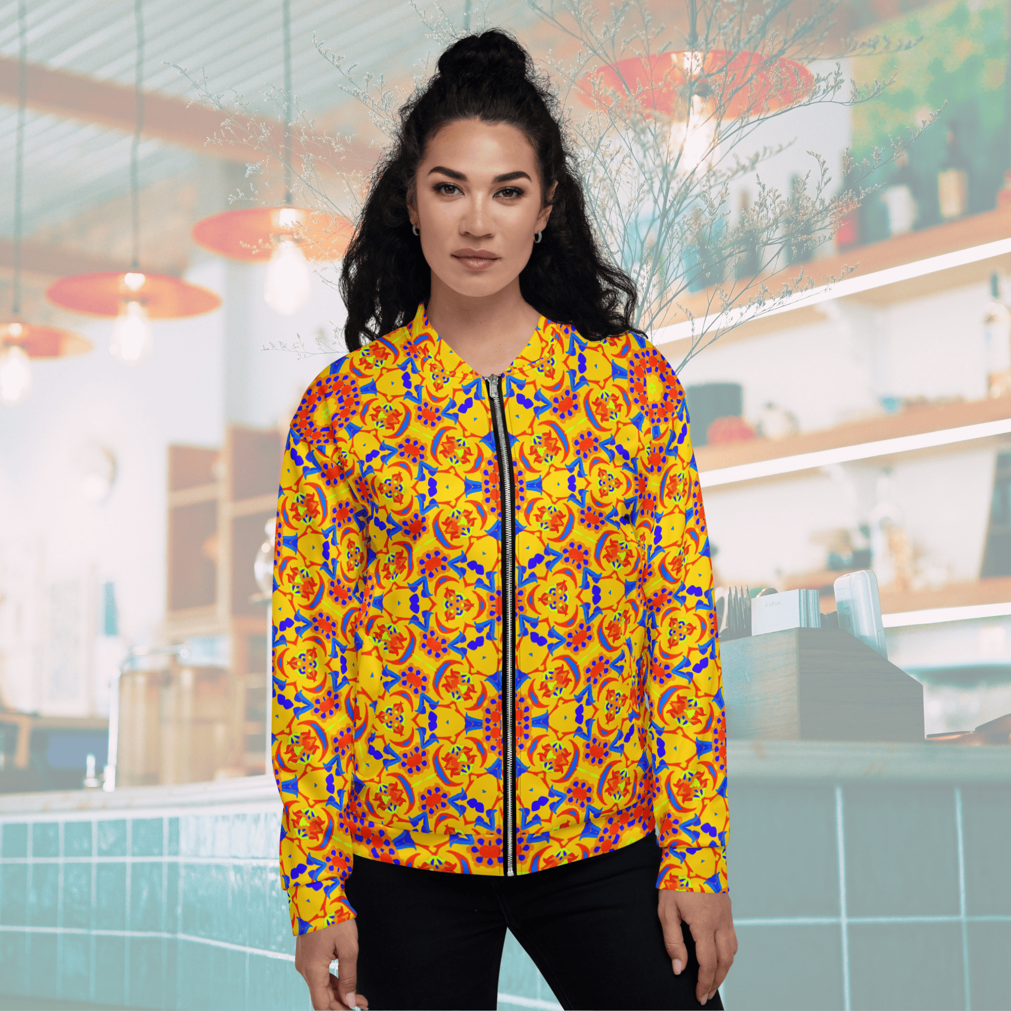 Direct front portrait of a woman wearing a yellow, full-zip geometric print bomber jacket, highlighting the symmetrical pattern placement across the front closure.