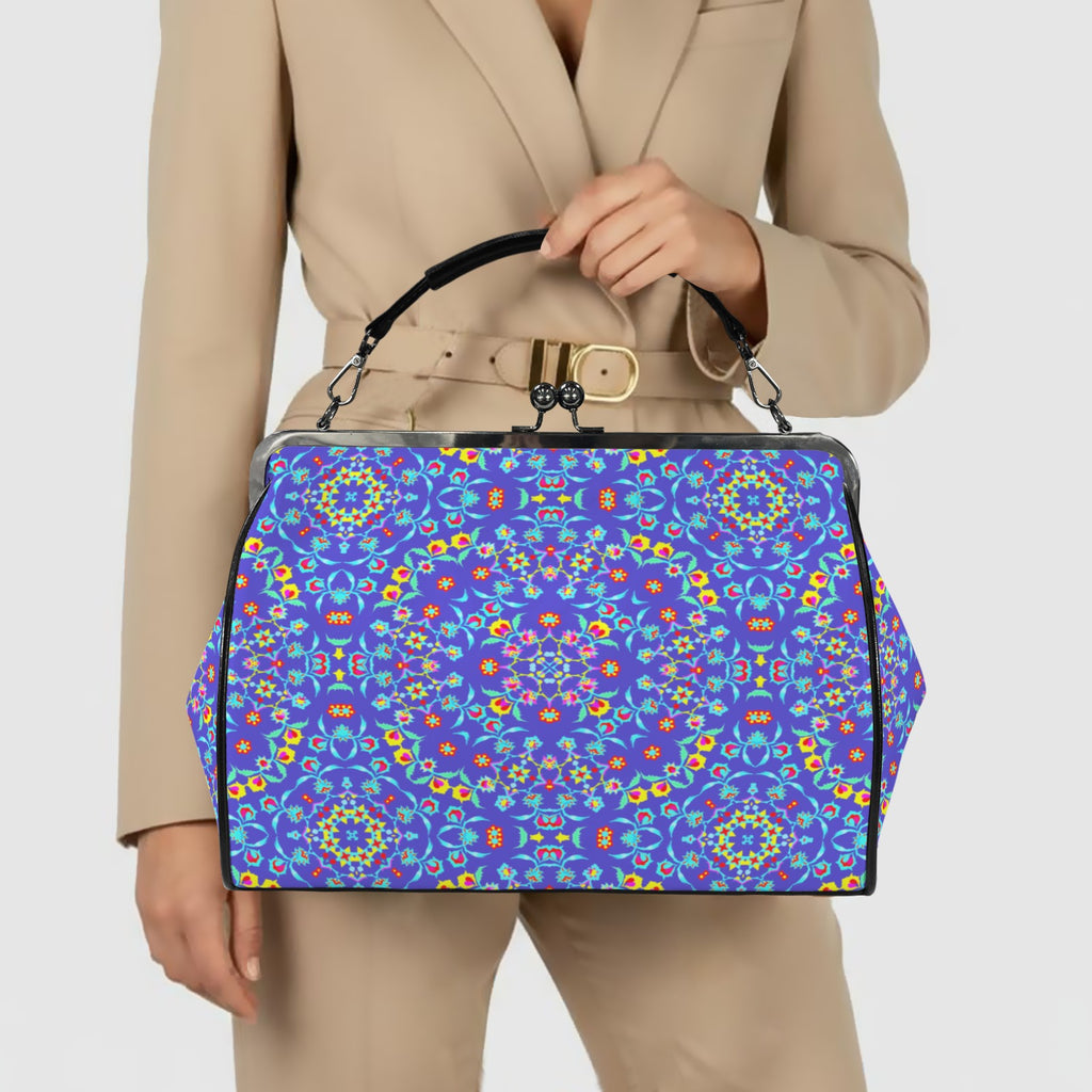 Model in neutral blazer holding the cobalt blue floral kiss lock handbag